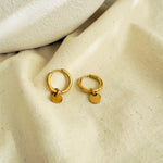 Load image into Gallery viewer, Gold hoop earrings with small round tags on a beige fabric background
