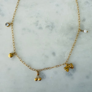 Gold charm necklace made of stainless steel with a zirconia, heart, cherries, bow and pearl charms