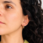 Load image into Gallery viewer, Model wearing gold oval hoop earrings
