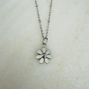Silver flower pendant necklace on a light background