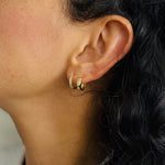 Load image into Gallery viewer, Model wearing a stack of different style of cubic zirconia hoop earrings
