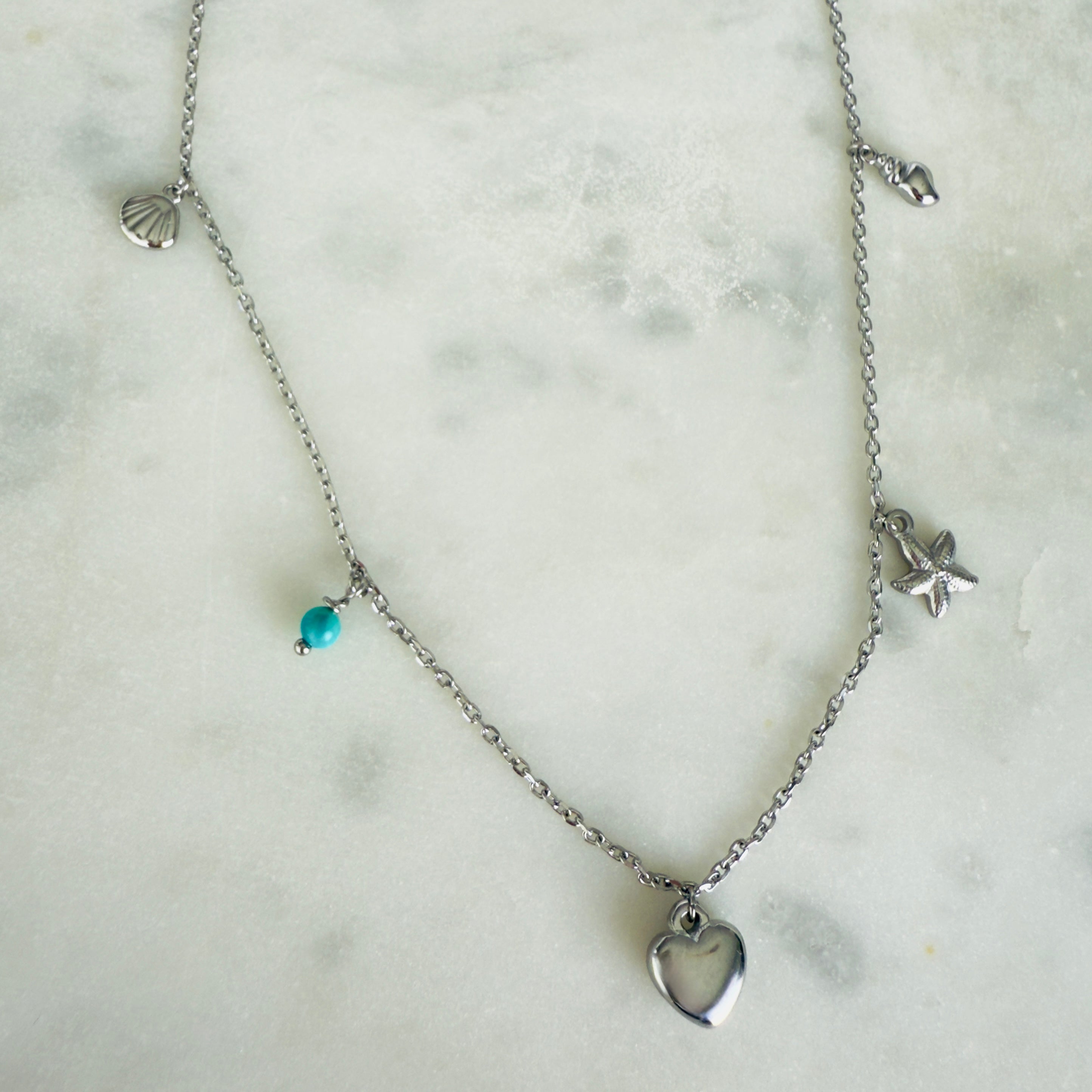 Stainless Steel charm necklace with a shell, turquoise, heart, starfish and conch charms