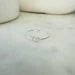 Load image into Gallery viewer, Silver ring with a knot design on a marble surface
