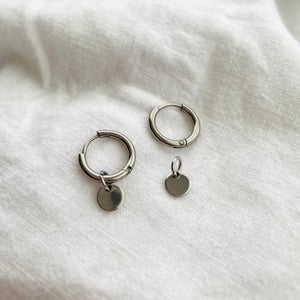 silver hoops with a small round tag charm